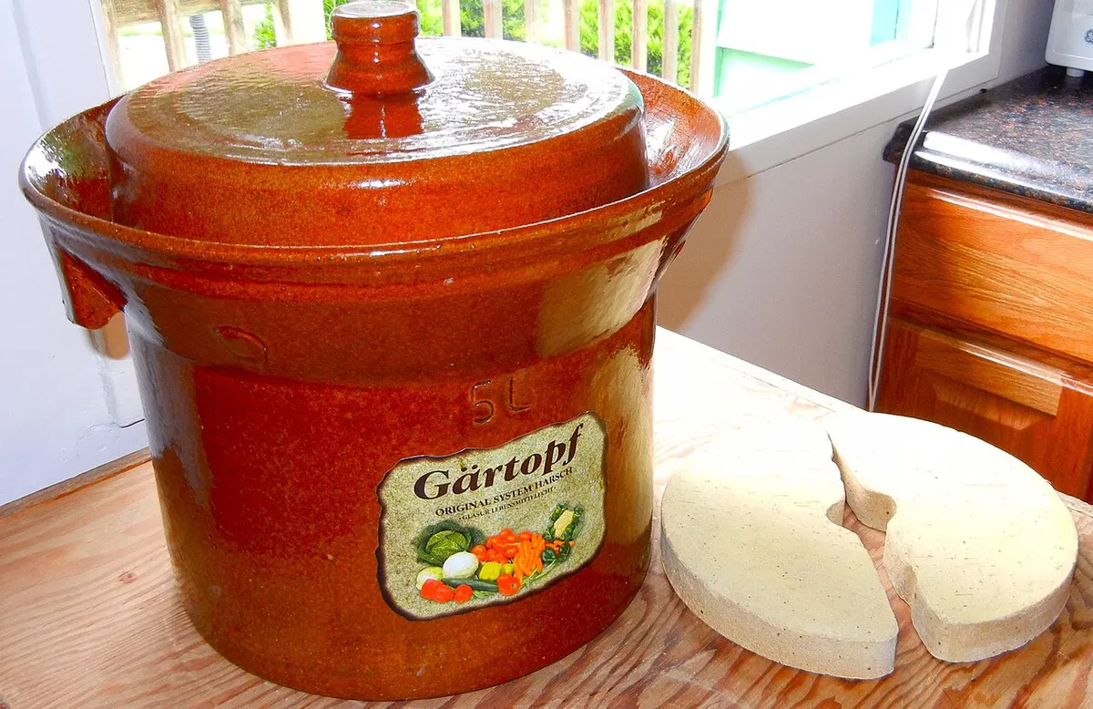 A water-seal stoneware fermentation crock with ceramic weights